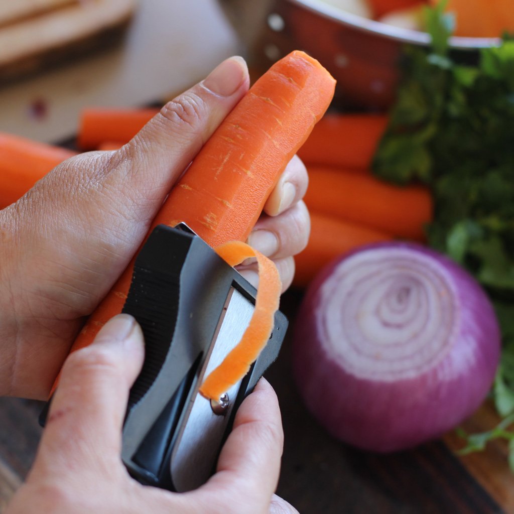 Karoto peeler making carrot curls on a kitchen counter